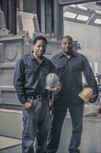 African American workers standing together in factory