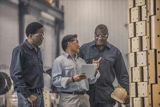 Workers looking at equipment in factory