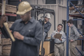 Workers talking together in factory