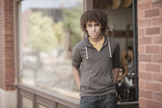 Mixed race teenager standing outside music store