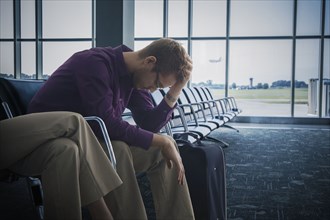 Frustrated Caucasian man sitting airport