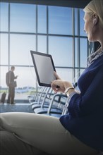 Caucasian woman using digital tablet in airport