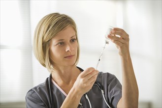 Caucasian nurse filling syringe
