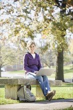 Caucasian student using laptop on campus