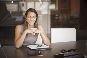 Mixed race businesswoman smiling at desk