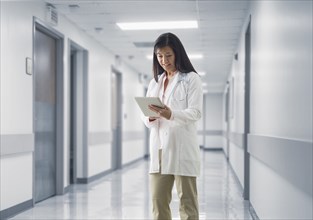 Asian doctor reading medical chart in hospital