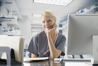 Caucasian nurse working at computer in hospital