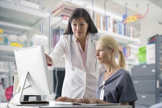 Doctor and nurse working at computer in hospital