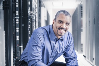 Mixed race businessman sitting in server room