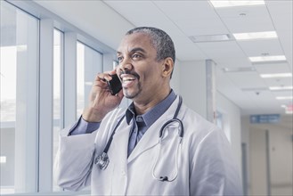 Mixed race doctor talking on cell phone in hospital