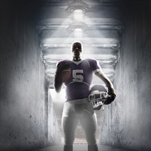 African American football player standing in hallway