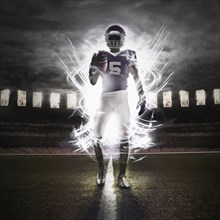 African American football player illuminated on field