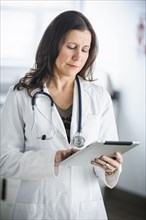 Caucasian doctor using tablet computer in office