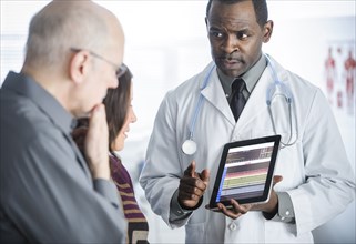 Doctor showing tablet computer to patients