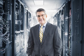 Caucasian businessman smiling in server room