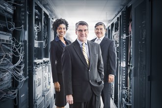 Businesspeople smiling in server room