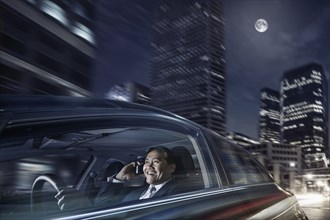 Pacific Islander businessman driving on cell phone