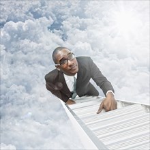 African American businessman climbing ladder