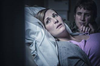Worried couple in hospital bed