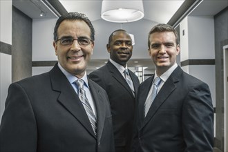 Businessmen smiling in office corridor