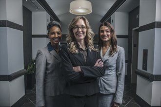 Businesswomen smiling in office corridor