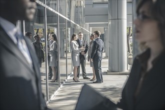 Business people talking outside office building