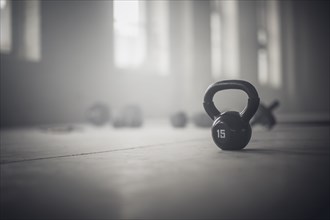 Close up of kettlebell weights on floor of dark gym