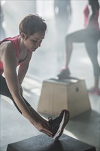 Athlete stretching leg in gym