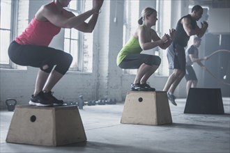Athletes crouching on platforms in gym