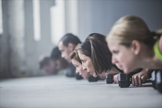 Athletes doing push-ups and lifting weights on floor