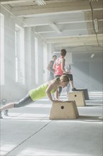 Athlete doing push-ups on platform in gym