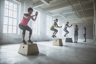 Athletes jumping on platforms in gym