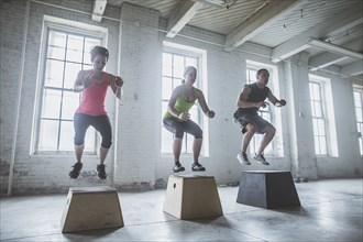 Athletes jumping on platforms in gym