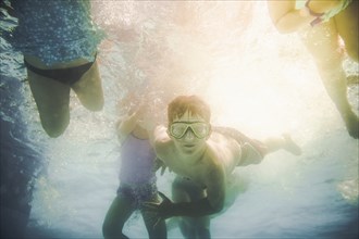 Children swimming underwater in swimming pool
