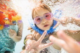 Caucasian children swimming underwater in swimming pool