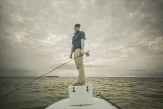 Caucasian fisherman standing on boat