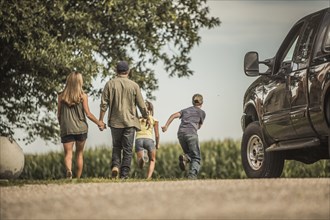 Caucasian family walking on farm
