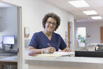 African American nurse writing in hospital