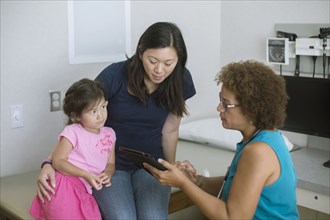 Doctor using digital tablet with patients