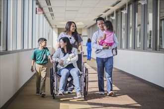 Nurse with patient and family in hospital hallway