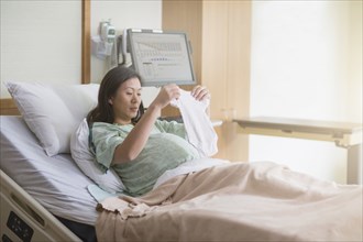 Pregnant Chinese woman in hospital bed