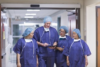 Surgeons using digital tablet in hospital hallway