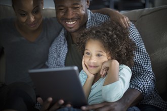 Family using digital tablet on sofa