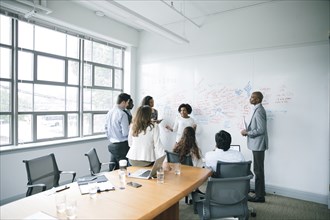Businesswoman talking near whiteboard in meeting