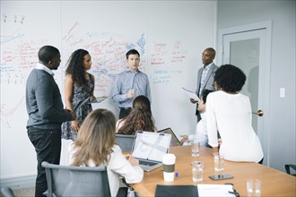 Businessman talking near whiteboard in meeting