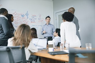 Businessman talking near whiteboard in meeting