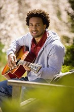 African American man playing acoustic guitar