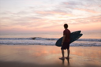 Man holding surfboard at beach
