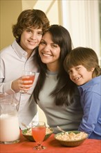 Hispanic mother and sons eating breakfast