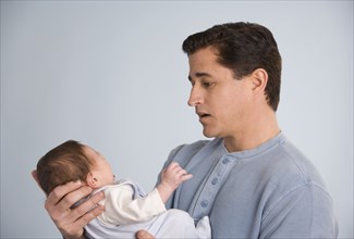 Hispanic father holding baby